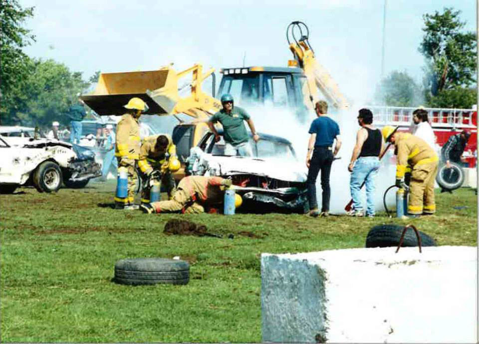 Man crawling out of car in demolition derby